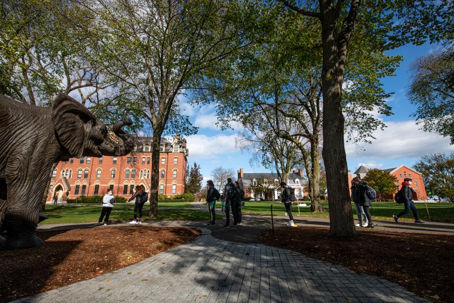 Students walking near the Jumbo Statue at Tuft's University on a sunny day