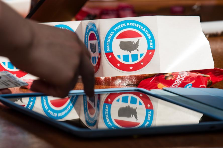 Red and blue round stickers that read "National Voter Registration Day" with an image of the U.S. in the center