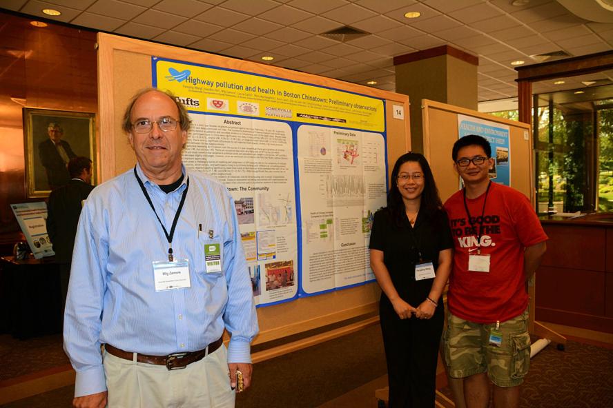 three people standing in front of a research poster
