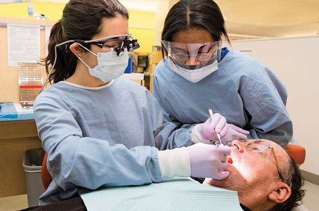 dental student with an assisting high school student