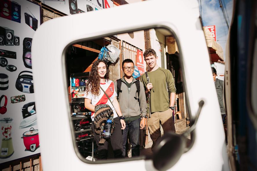 three students viewed through a square sculpture in Peru