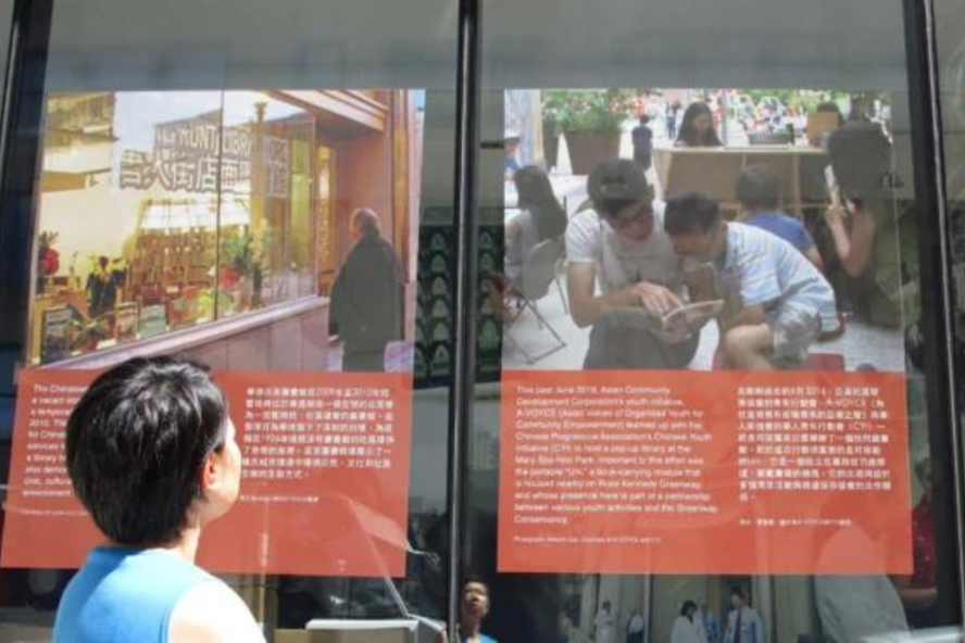 a person looks at exhibit panels for "These Words" in Boston's Chinatown