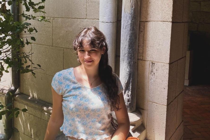 Image of Eva Lachavanne, in front of a wall and tree