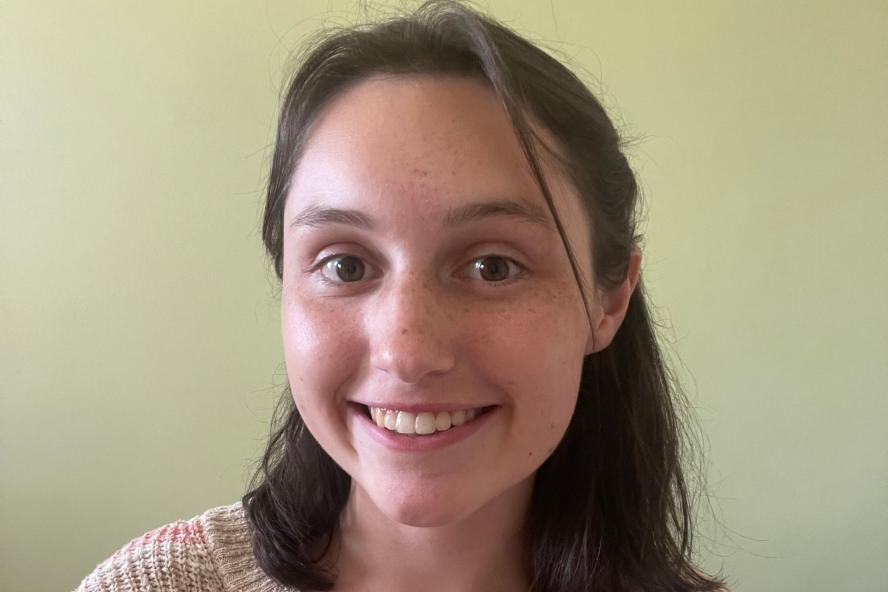 Image of Leah, a civic semester student, in front of a green wall
