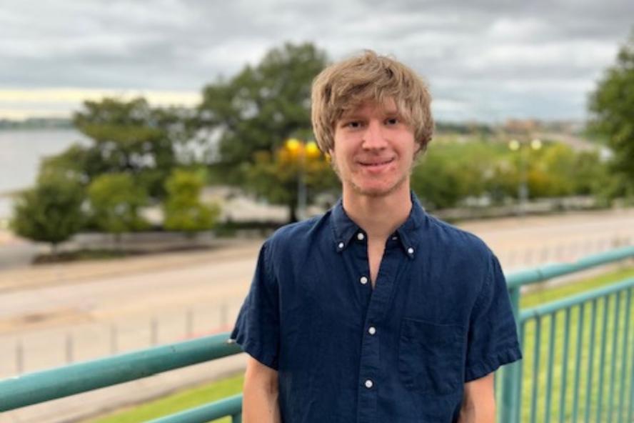 Image of William Ferguson, a civic semester student, in front of a green fence