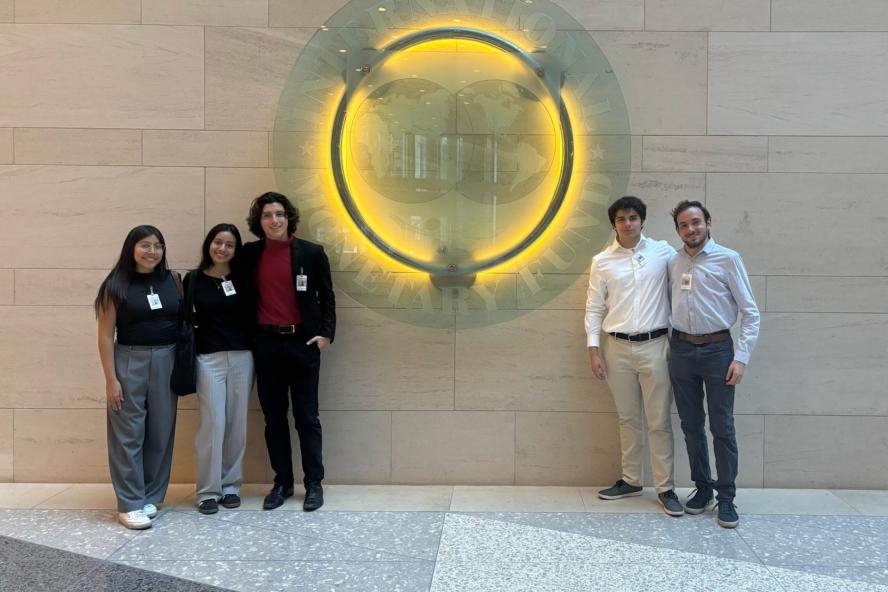 Students pose in front of illuminated sign