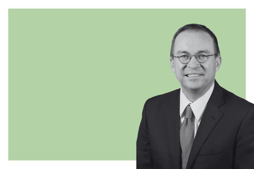 Person smiling against a green background. 