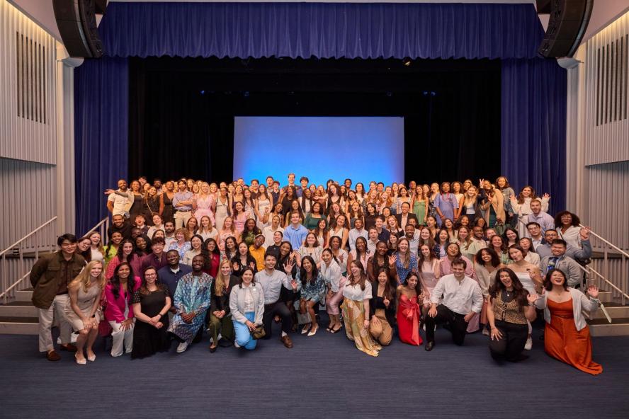 A group photo of students inducted into Honos Civicus in a large auditorium