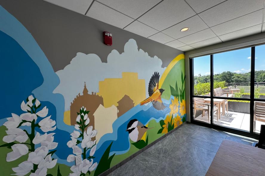 A mural with flowers and a bird at Medford Housing Authority's Saltonstall apartments