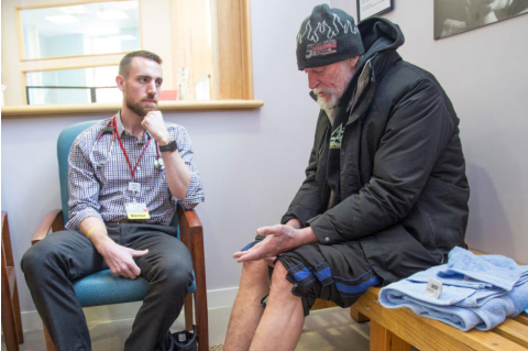 physician Adam Normandin listens to a homeless man at a Portland, Maine clinic