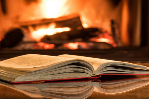 open book in front of a fireplace