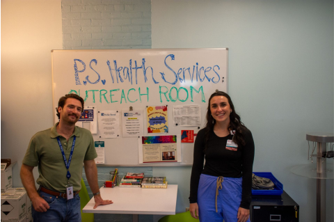 Tisch Summer Fellows pose in front of a white board rading P.S. Health Services Outreach Room