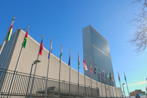 An exterior photo of the United Nations building in New York, with flagpoles outside. A book about former UN Secretary-General Kofi Annan’s leadership offers insights into the organization’s successes and challenges