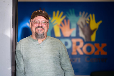 Nathan Miksch leans in a doorway with the STEPRox logo behind him